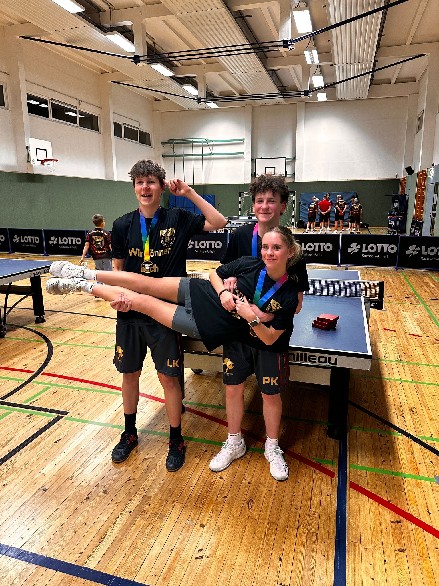 Junge Spieler mit Medaillen am Tischtennistisch